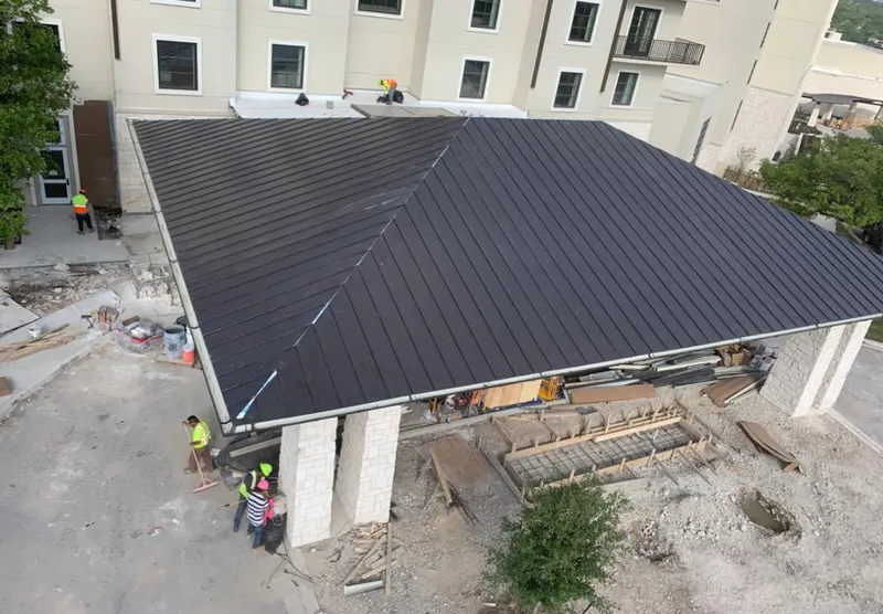 Metal roofing installation team working on a commercial building in Stoughton